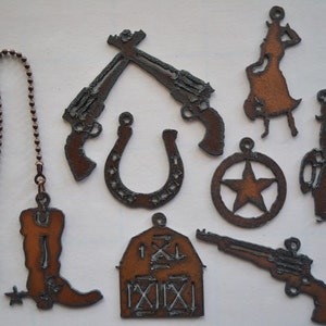 May include: A set of nine rustic metal western-themed ornaments, including a horseshoe, a star, a boot, a barn, two pistols, and two cowboys. The ornaments are all made of metal and have a brown, rusty finish.