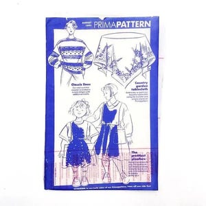 Könnte beinhalten: Ein Vintage-Cover des Prima Pattern Magazins vom August 1995 mit Illustrationen von Kleidungsdesigns. Das Cover zeigt Zeichnungen eines Pullovers, einer Tischdecke und zweier Kinderkleider. Der Text enthält "Classic lines" und "Country garden tablecloth."
