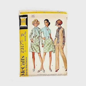 Op de afbeelding: Vintage McCall's 2317 naaipatroon met illustraties van damescoördinaten. Het patroon bevat een rokpak, een blouse en rok, en een broekpak. De omslag is geel en wit met het McCall's logo en maat informatie.