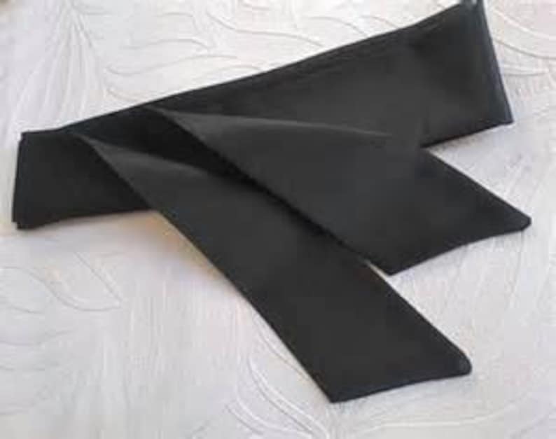 May include: A black satin ribbon with a long, flowing tail. The ribbon is tied in a simple knot.