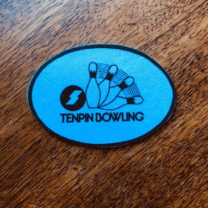 May include: A blue and black circular patch with a bowling ball and pins design. The text "TENPIN BOWLING" is printed below the image.