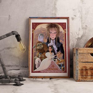 May include: Framed art print featuring characters from the movie Labyrinth. The artwork includes a central figure with long blonde hair, a woman in a white dress, and various fantasy creatures. A rustic metal pipe lamp and a wooden crate are also in the image.