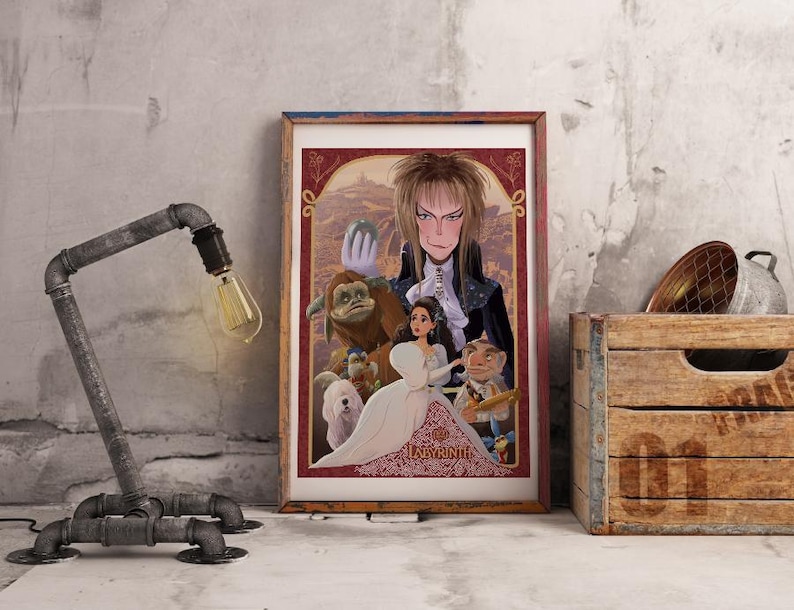 May include: Framed art print featuring characters from the movie Labyrinth. The artwork includes a central figure with long blonde hair, a woman in a white dress, and various fantasy creatures. A rustic metal pipe lamp and a wooden crate are also in the image.