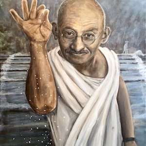 Gandhi sprinkles a pinch of salt wearing his white Khadi and glasses