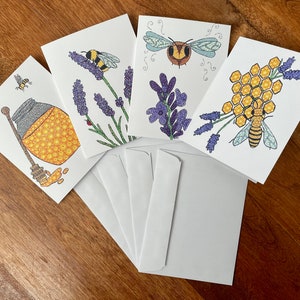 May include: Five blank greeting cards with bee and honey themed illustrations. The cards feature bees, honeycombs, lavender flowers, and a jar of honey. The cards are white with a subtle texture.