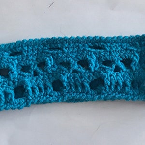 May include: A turquoise blue crocheted trim with a repeating pattern of openwork squares.