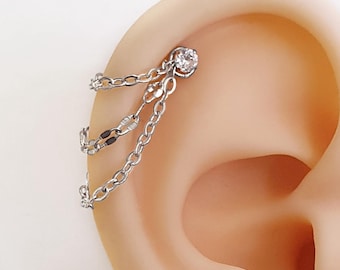 Piercing met drie kettingen en industriële helixkristallen of dubbele ringen. Zilveren kettingoorbellen voor kraakbeenpiercings of schakelringen.