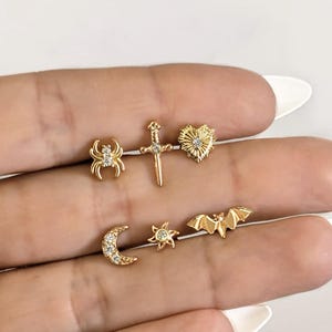 Sword bat spider sun moon heart piercing .  Helix tragus lobe snug conch piercing in stainless steel . Gold bar earring piercing halloween