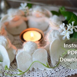 May include: A white felt angel ornament with glitter wings, surrounded by other angels and a lit candle. The angels are arranged in a circle on a white crocheted doily. The text "Instant PDF Download" is visible in the lower right corner of the image.