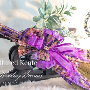 Handcrafted cultured Kente wedding broom by African American Bridal, featuring vibrant multicolor purple and gold  Kente cloth, cowrie shell accents, gold bead detailing, and purple organza bow, designed to honor the African American wedding tradition of jumping the broom.