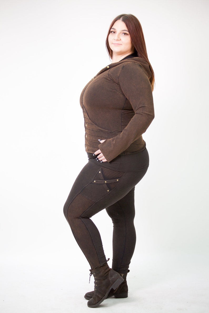 May include: A brown hooded jacket with a zip fastening and a brown pair of leggings with decorative stitching and gold accents. The model is wearing brown boots.