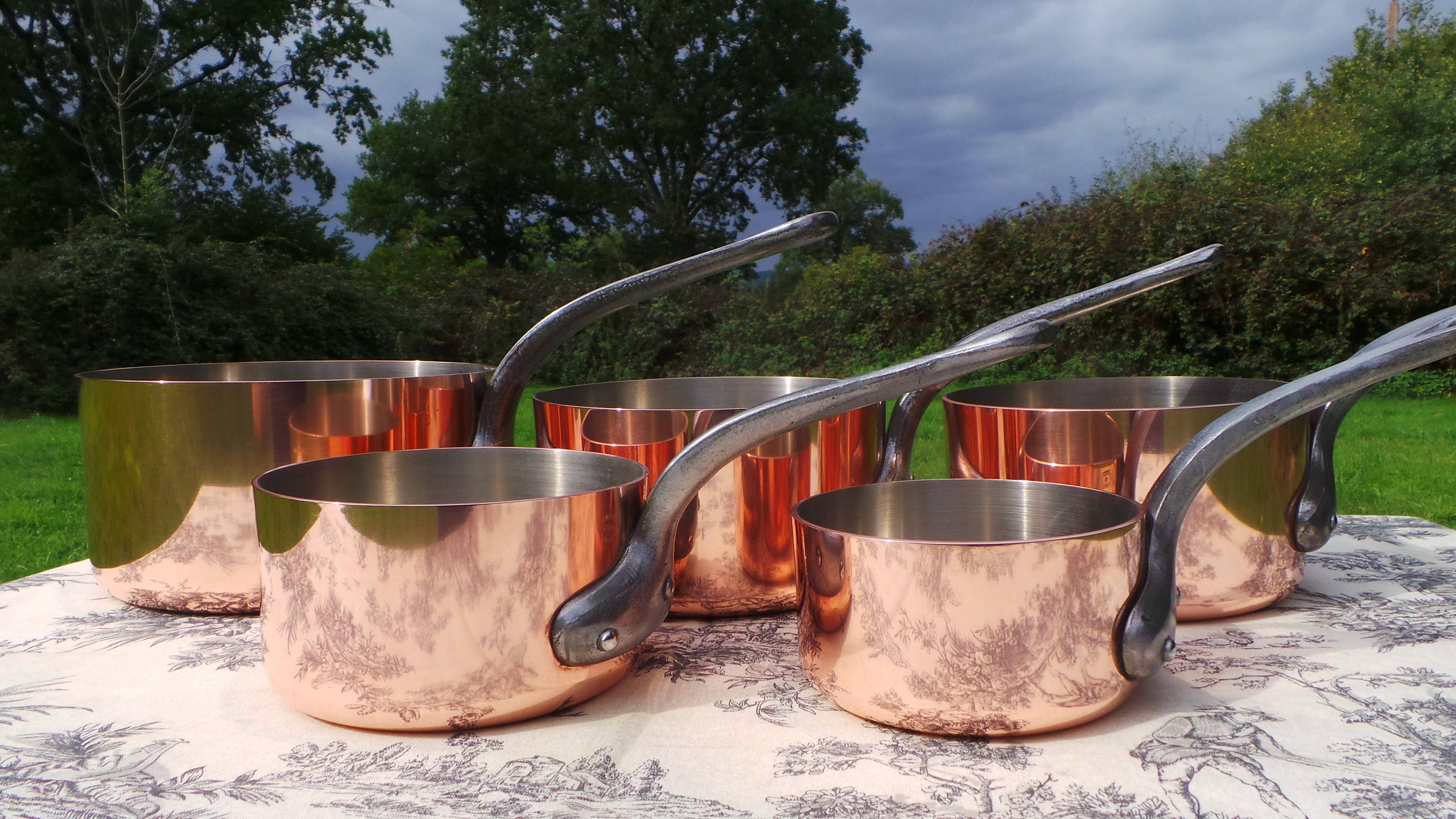 Lot - A group of graduated French copper cookware, Bridge
