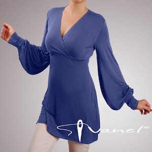May include: A blue long-sleeved tunic top with a V-neckline and a wrap-style bodice. The sleeves are gathered at the wrists and the hemline is slightly longer in the back.