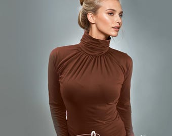 May include: A brown long-sleeved turtleneck shirt with a gathered neckline.
