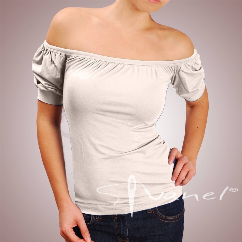 May include: A white off-the-shoulder top with short, puffed sleeves. The top is made of a soft, stretchy fabric and has a relaxed fit.