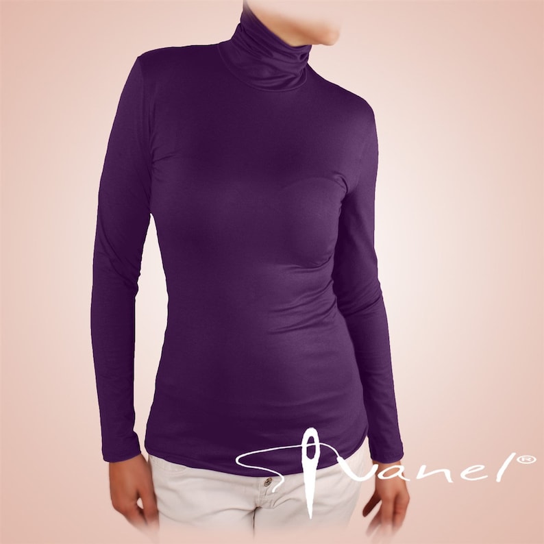 May include: A long-sleeved, purple turtleneck shirt. The shirt is made of a soft, stretchy fabric and has a fitted silhouette.