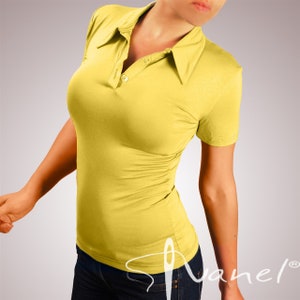 May include: A yellow short-sleeved polo shirt with a button-up collar. The shirt is made of a soft, stretchy fabric and has a fitted silhouette.