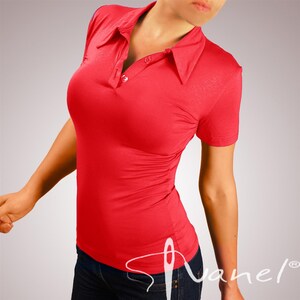 May include: A red short-sleeved collared shirt with a button closure. The shirt is fitted and has a slightly gathered look in the front.
