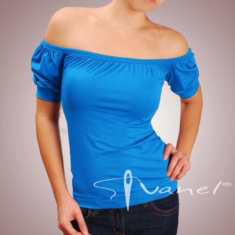May include: A bright blue off-the-shoulder top with short sleeves. The top is made of a soft, stretchy fabric and has a relaxed fit.