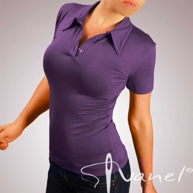 May include: A purple short-sleeved collared shirt with a button closure. The shirt is made of a soft, stretchy fabric and has a fitted silhouette.