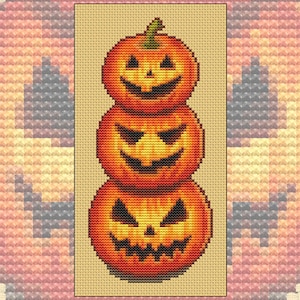 以下が含まれることがあります： 3つのオレンジ色のカボチャが積み重ねられており、それぞれにジャック・オ・ランタンの顔が彫られています。一番下のカボチャが一番大きく、一番上のカボチャが一番小さいです。