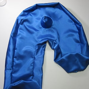 May include: A blue satin travel pillow shaped like a U. The pillow is folded in half and the opening is visible.
