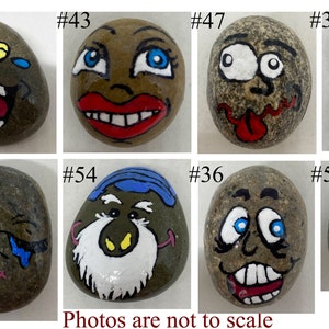 May include: Eight painted rocks with different facial expressions. The rocks are numbered 34, 43, 47, 30, 53, 54, 36, and 52.