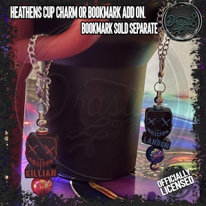 May include: Two metal chain charms featuring black square beads with stitched face graphics and the names Killian and Landon. The charms include metallic lobster clasps, silver-toned spacers, and colorful spherical beads. Text reads: HEATHENS CUP CHARM OR BOOKMARK ADD ON. BOOKMARK SOLD SEPARATE.