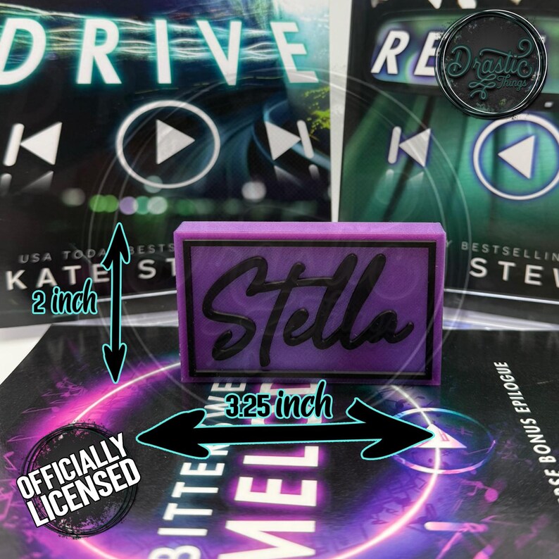 May include: A rectangular, purple Stella nameplate, 3.25 inches wide and 2 inches tall, with black lettering. The nameplate is set against a background of book covers. The image includes the text "Officially Licensed."