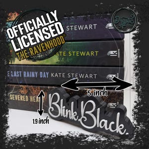 Op de afbeelding: Zwarte "Blink Black" boekensteun, 12,7 cm lang en 4,8 cm hoog, met witte cursieve tekst. De boekensteun staat voor een stapel boeken van Kate Stewart. De afbeelding bevat de tekst "OFFICIALLY LICENSED THE RAVENHOOD".