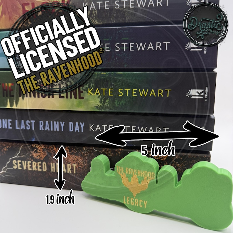 Op de afbeelding: Een stapel boeken van Kate Stewart, waaronder "Severed Heart". Een groen, 12,7 cm lang, "The Ravenhood Legacy" gevormd object staat op de voorgrond. De boeken zijn ongeveer 4,8 cm hoog. De afbeelding bevat de tekst "Officieel gelicentieerd The Ravenhood."