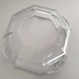 Puede incluir: Cuenco de vidrio transparente y facetado, con forma octogonal. El cuenco tiene un dise&ntilde;o geom&eacute;trico y un interior amplio y poco profundo. Los bordes son ligeramente texturizados y el vidrio refleja la luz. Una pieza decorativa para servir o exhibir.