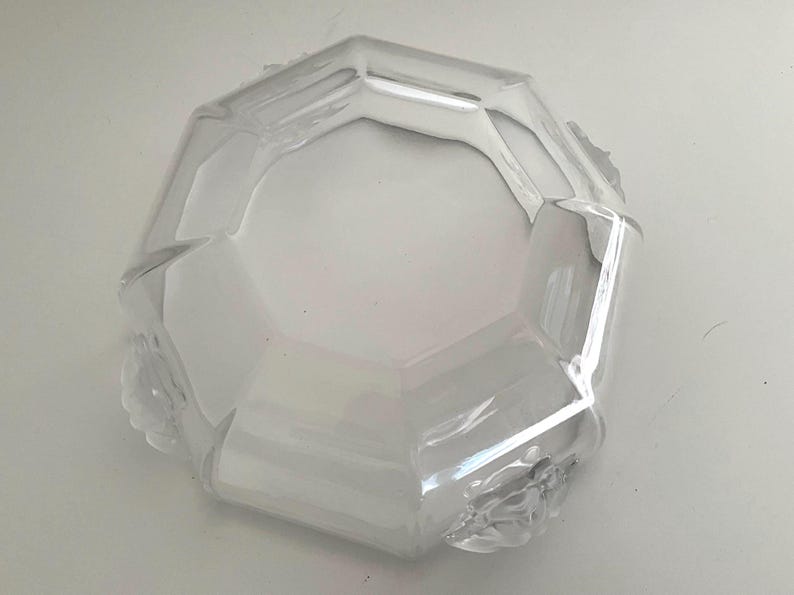 Puede incluir: Cuenco de vidrio transparente y facetado, con forma octogonal. El cuenco tiene un dise&ntilde;o geom&eacute;trico y un interior amplio y poco profundo. Los bordes son ligeramente texturizados y el vidrio refleja la luz. Una pieza decorativa para servir o exhibir.