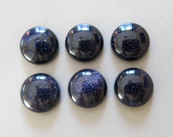 May include: Six round, blue, sparkly cabochon stones. The stones have a dark blue colour with a subtle sparkle.