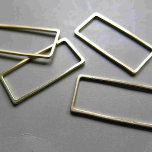 Puede incluir: Cuatro marcos rectangulares de metal de color dorado de diferentes tamaños. Los marcos están abiertos y tienen un acabado liso y pulido.
