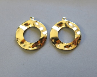 May include: Two gold-toned metal circles with a hammered texture and a hole at the top for hanging. The circles are about 2 inches in diameter.