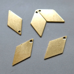 Pode incluir: Cinco pingentes de metal em forma de diamante de cor dourada com um furo no topo.