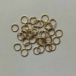 Könnte beinhalten: Ein Haufen goldener Sprungringe, eine Art Metallring, der in der Schmuckherstellung verwendet wird.