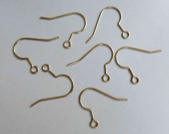 May include: Six gold-toned earring hooks, each with a small loop at the end. These hooks are commonly used for making earrings.
