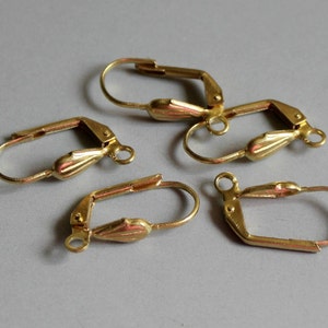 Puede incluir: Cuatro ganchos para pendientes de color dorado con un diseño en forma de lágrima. Los ganchos son de metal y tienen un cierre de resorte.