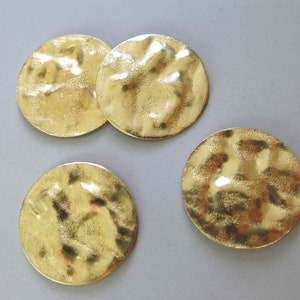 以下が含まれることがあります： 表面がテクスチャ加工された、金色の丸い金属製の装飾品が4つあります
