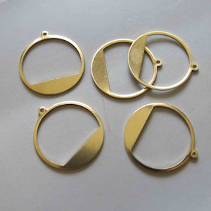 Pode incluir: Cinco círculos de metal de cor dourada com uma secção recortada. Cada círculo tem uma forma recortada diferente.