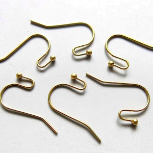 May include: Six gold-toned earring hooks with small round balls at the end. The hooks are made of metal and are designed for hanging earrings.