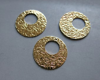 May include: Three gold-colored metal circles with a textured surface and a hole in the center.