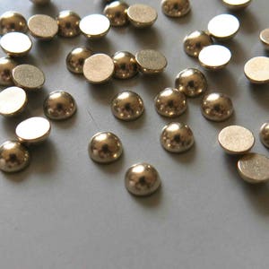 以下が含まれることがあります： クラフトやジュエリー作りに最適な、金色のドーム型の金属製装飾品のコレクションです。