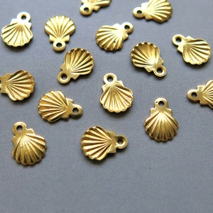 May include: A collection of 14 gold-colored metal seashell charms with a loop at the top for attaching to jewelry or other crafts.