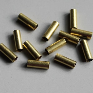 Puede incluir: Un grupo de 11 tubos de metal de color dorado, probablemente utilizados para la fabricaci&oacute;n de joyas o proyectos de artesan&iacute;a.