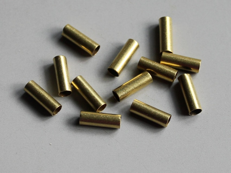 Puede incluir: Un grupo de 11 tubos de metal de color dorado, probablemente utilizados para la fabricaci&oacute;n de joyas o proyectos de artesan&iacute;a.