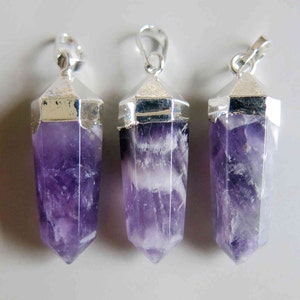 May include: Three amethyst crystal pendants with silver settings. The crystals are a deep purple color and have a pointed shape.