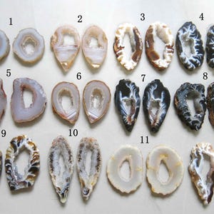 May include: A selection of twelve polished agate slices in diverse shapes and colours. The slices display natural patterns with shades of white, brown, black, and grey, showcasing the unique crystal formations. Suitable for jewellery making or decorative use.